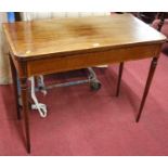 An early 19th century mahogany and rosewood crossbanded fold-over card table, having baize-lined