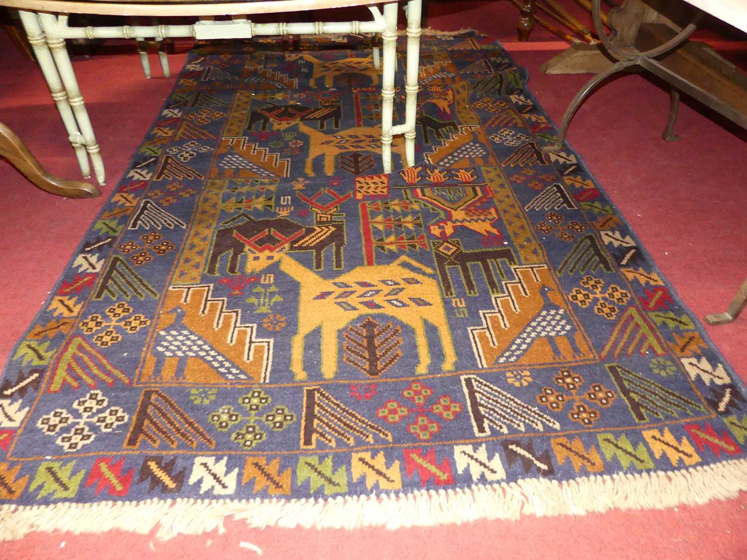 A Turkish woollen multi-coloured ground pictorial rug, with stylised design of animals and