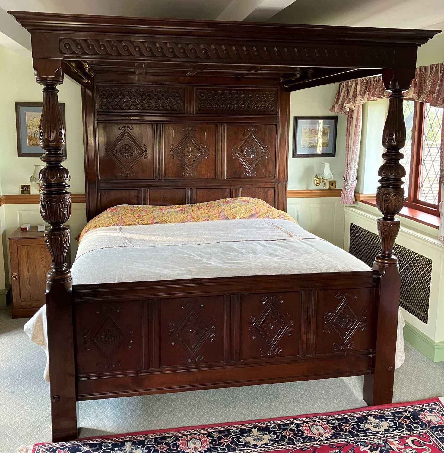 A contemporary joined cherry wood floral relief carved and panelled full tester bed, in the 17th