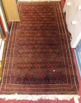 A Persian woollen red ground Bokhara rug, with repeating central ground within tramline borders, 183
