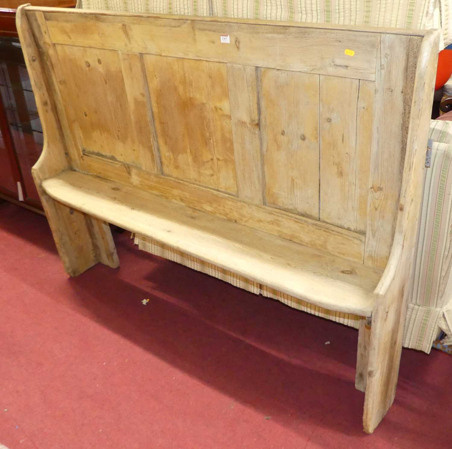 A rustic joined and panelled pine bench settle, of narrow profile, length 158cm