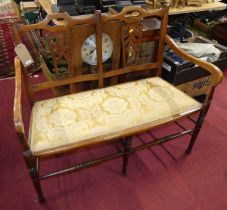 An Edwardian beech two-seater salon settee, having a mustard floral damask fixed pad seat, w.108cm