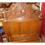 An early 20th century Belgian panelled oak single bedstead, having floral shaped and carved