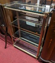 A 1970s gilt and brushed brass freestanding four-tier display stand, with glass inset shelves,