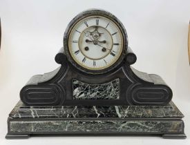 A late Victorian slate mantel clock of architecturally influenced outline having visible escapement,