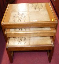 A 1970s teak and tile-top inset nest of three occasional tables