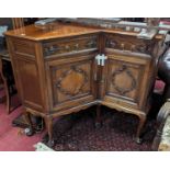 An Edwardian mahogany freestanding corner cabinet, having single frieze drawer, dummy drawer, and