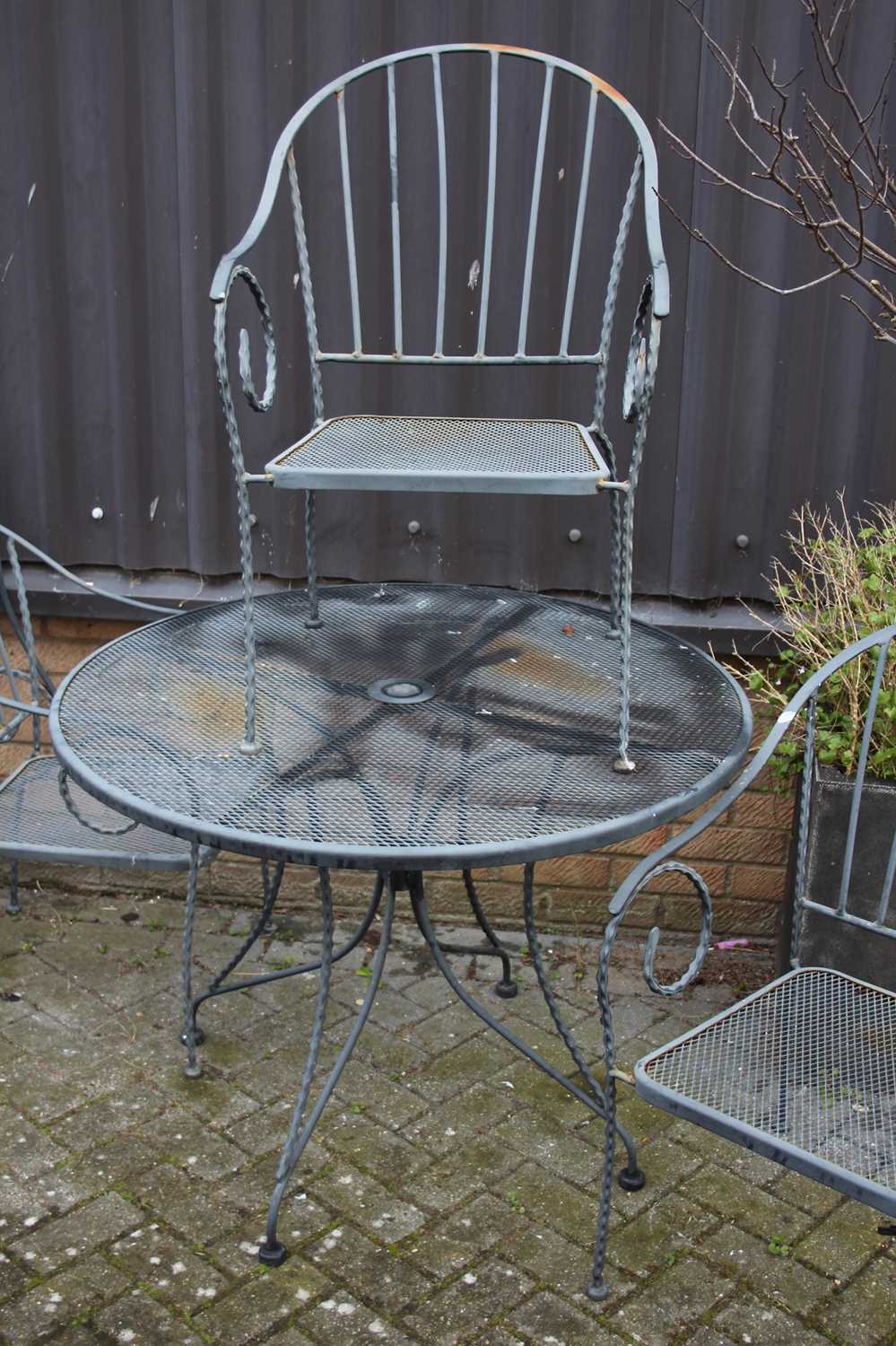 A wired metal patio suite comprising circular table and four tub elbow chairs (5) Appears to be