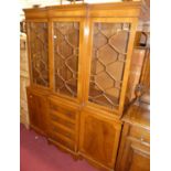A reproduction yew wood breakfront bookcase, having three astragal glazed upper doors over four