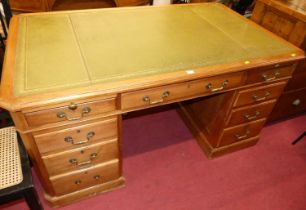 An early 20th century walnut and gilt-tooled green leather inset twin pedestal writing desk,