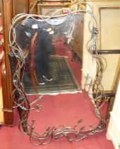 A contemporary floral wirework decorated steel shaped wall mirror, in the gothic taste, 124 x 85cm