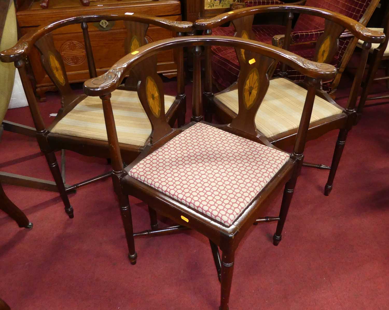 A set of four contemporary mahogany tub corner chairs, each with panelled seats