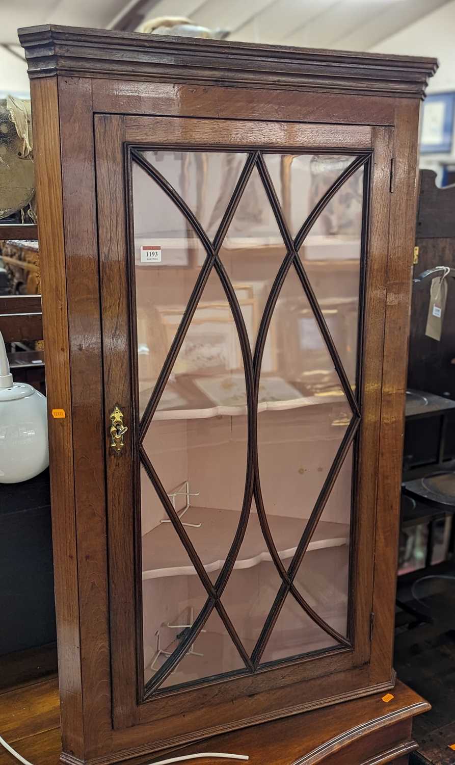 An early 19th century fruit wood single door astragal glazed hanging corner cabinet, height 109cm