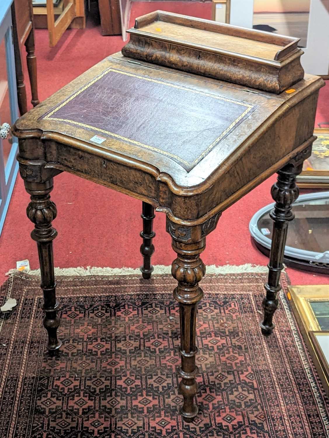 A mid-Victorian figured walnut slope front Davenport, having hinged stationery compartment, gilt
