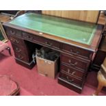 A contemporary mahogany and gilt tooled green leather inset twin pedestal writing desk, having an
