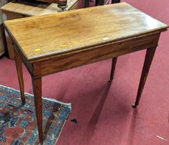 An early 19th century mahogany fold-over tea table, with rear gateleg action on square tapering