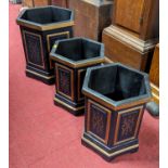 A pair of contemporary black and gilt painted hexagonal wastepaper bins; together with a larger