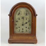 An early 20th century mahogany dome top mantel clock, having an unsigned silver dial and a three