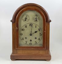 An early 20th century mahogany dome top mantel clock, having an unsigned silver dial and a three