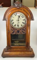 A late 19th century American walnut cased mantel clock, having an unsigned white enamel dial (