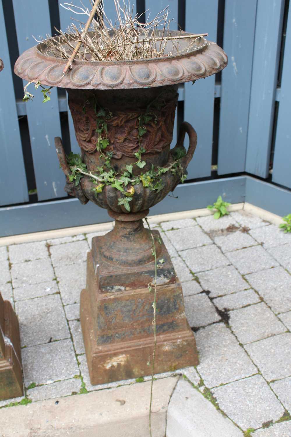 A pair of cast iron twin handled pedestal garden urns, raised on stepped tapering square bases, - Image 2 of 4
