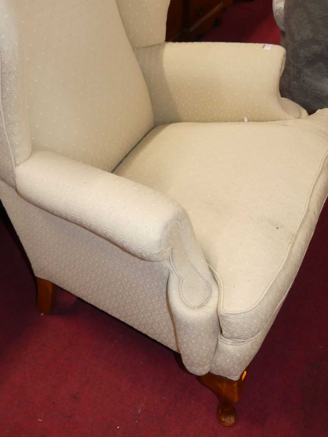 A contemporary cream floral fabric upholstered wingback scroll armchair, having squab cushion and - Image 2 of 4