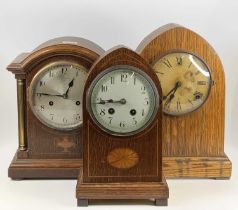 An Edwardian inlaid oak Gothic mantel clock, having unsigned convex white enamel dial, h.30cm;
