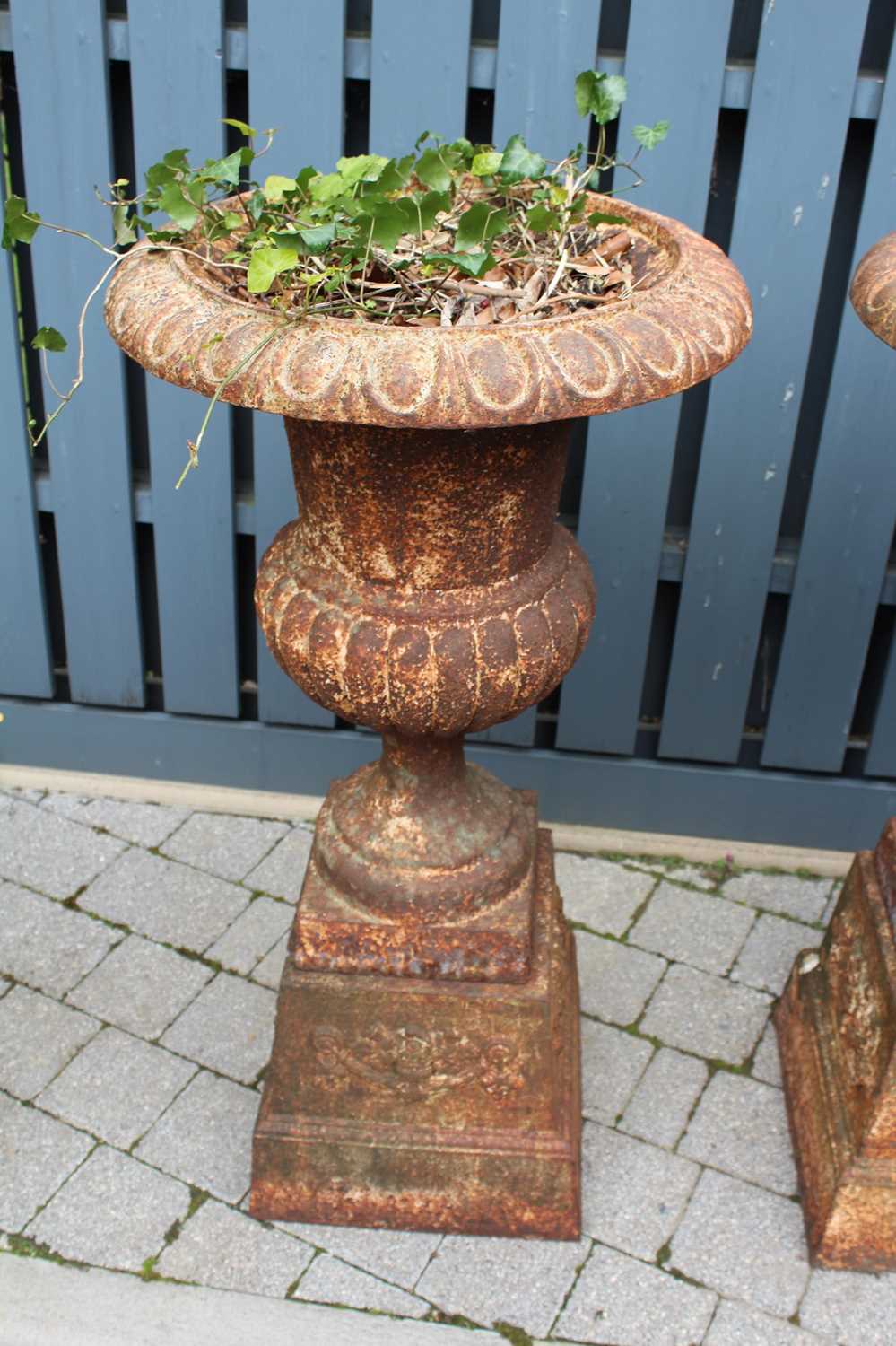 A pair of cast iron pedestal garden urns, each of reeded lower bulbous form and raised on square - Image 4 of 4