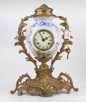 A reproduction gilt brass and soft paste porcelain pedestal mantel clock in the Dutch taste,