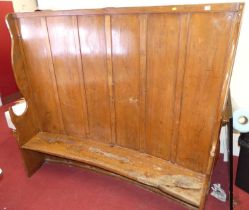 A 19th century elm curved bench settle, with six panel raised back, pronounced profile end arm