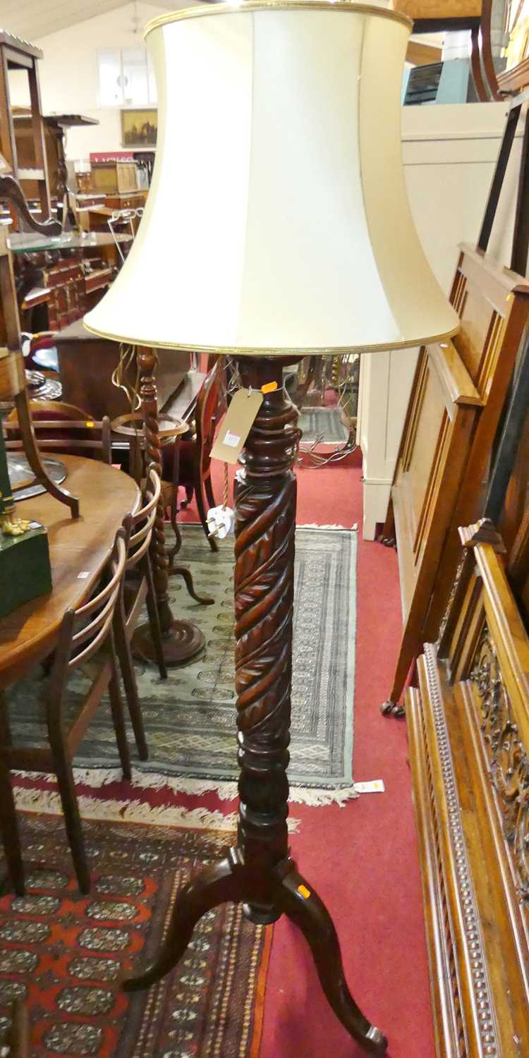 A mahogany acanthus leaf spiral turned standard lamp, raised on tripod hip supports (converted