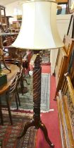 A mahogany acanthus leaf spiral turned standard lamp, raised on tripod hip supports (converted