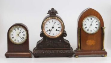 A late Victorian carved oak drumhead mantel clock having French brass eight-day cylinder movement,