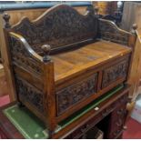 An Eastern joined and relief carved teak box seat settle, width 100.5cm