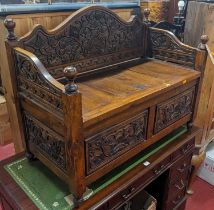 An Eastern joined and relief carved teak box seat settle, width 100.5cm
