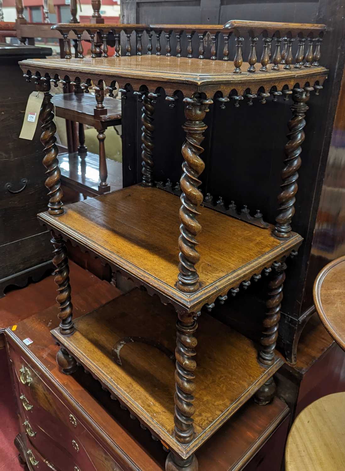 A mid-Victorian oak three-tier whatnot, having a three-quarter balustrade top, raised on spiral