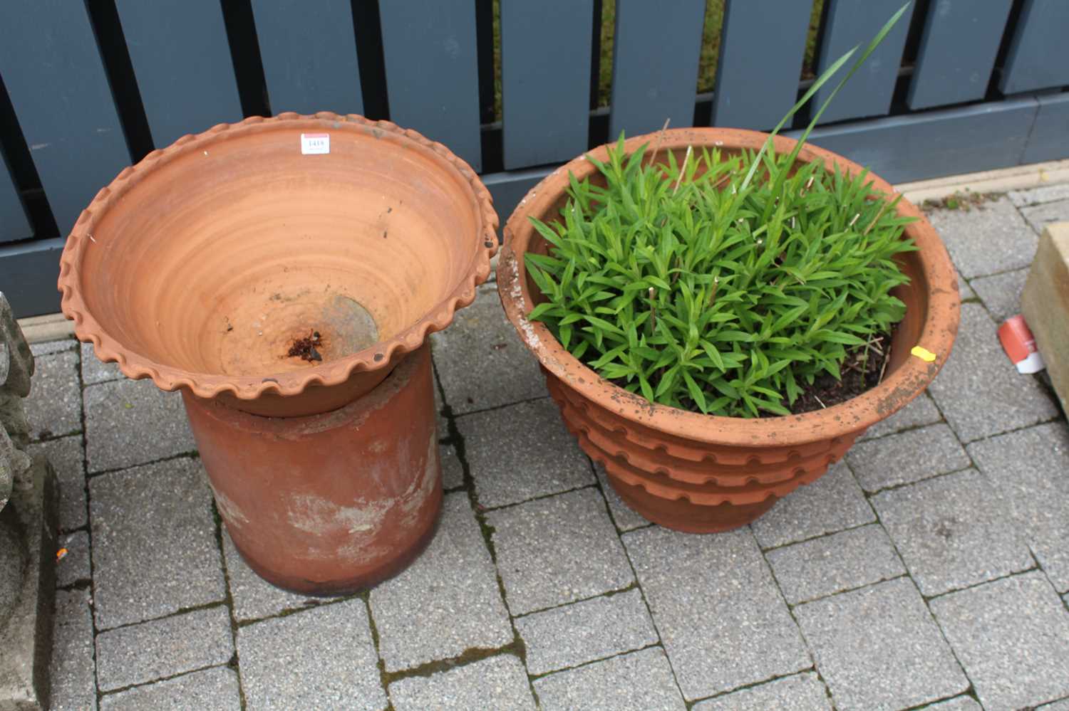 A terracotta circular garden planter, together with one other similar on base (2)