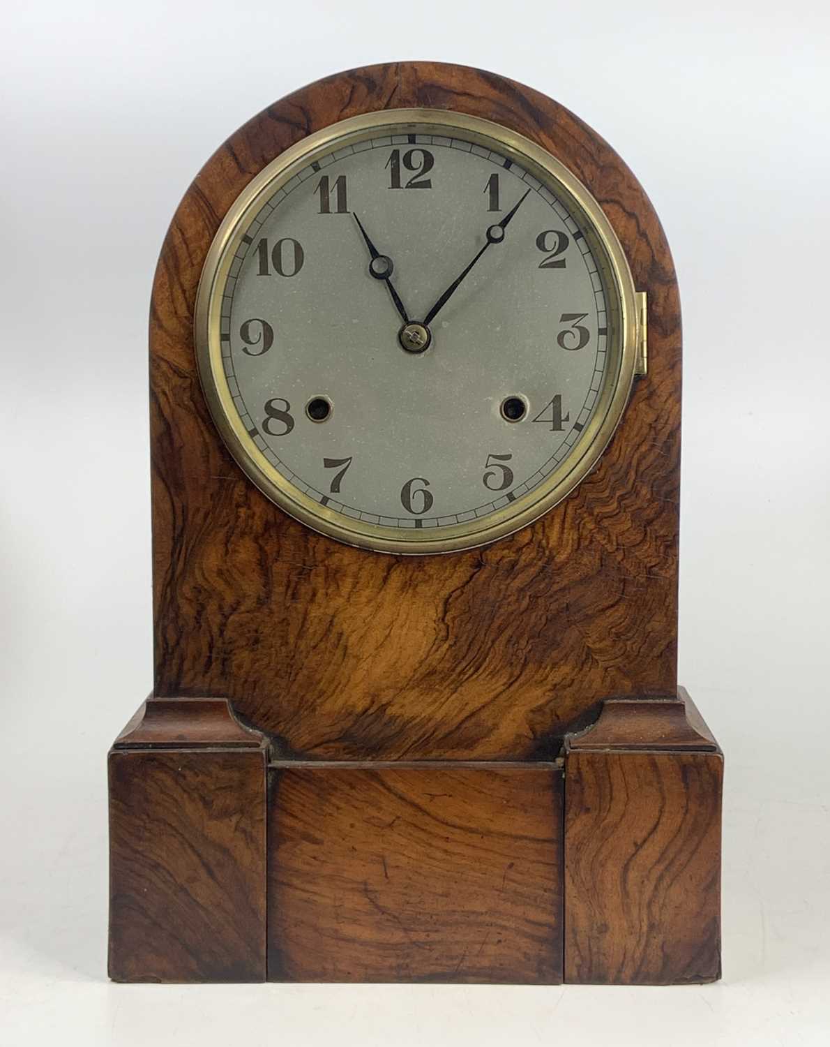 A late 19th century figured walnut dome top mantel clock, having an unsigned silver dial, and spring