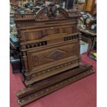An early 20th century French walnut double bedstead, having panelled head and foot board, with