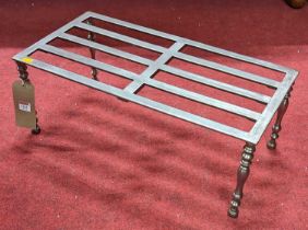 A 19th century steel footman, the slatted top raised on turned supports, length 61cm
