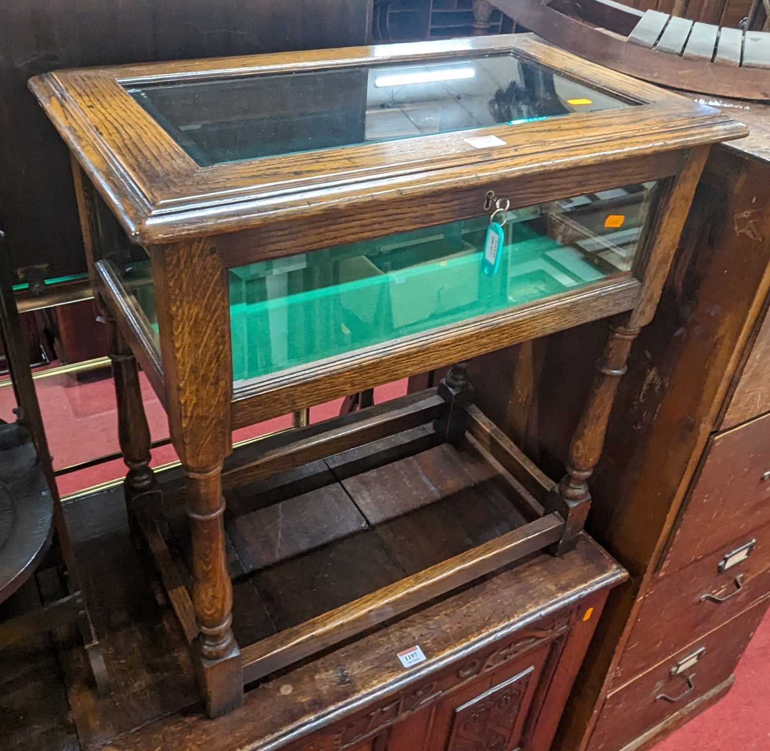 A contemporary joined oak and bevelled glass hinge top bijouterie table, on turned and square cut