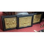 A set of three French gilt and embossed metal wall panels, each housed in ebonised frames