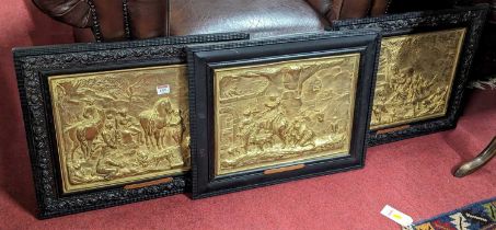 A set of three French gilt and embossed metal wall panels, each housed in ebonised frames