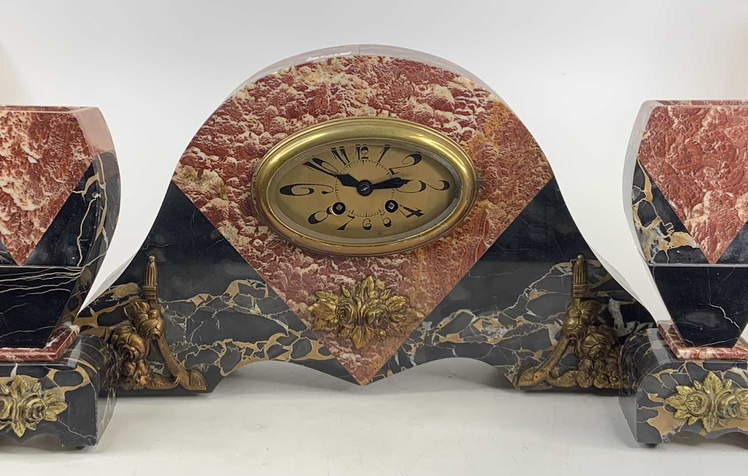 An Art Deco rouge marble three-piece clock garniture, clock height 26cm