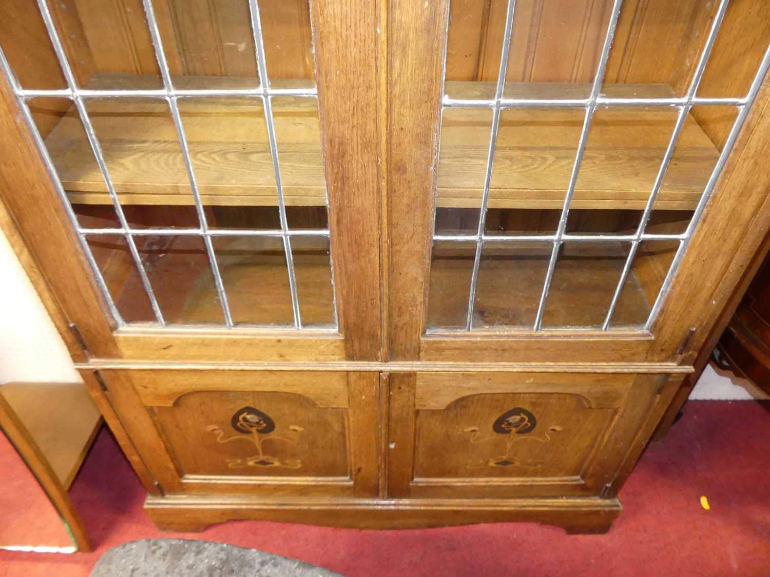 An Arts & Crafts oak double door lead glazed bookcase, with interior shelves over floral stylised - Image 3 of 4