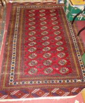A Persian woollen red ground Bokhara rug, having multiple tramline borders, 195 x 125cm
