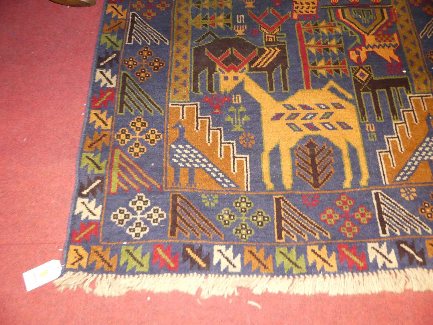 A Turkish woollen multi-coloured ground pictorial rug, with stylised design of animals and - Image 2 of 2