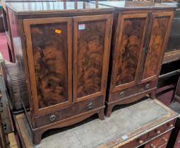 A pair of mahogany and flame mahogany small low double door side cupboards, each with single long