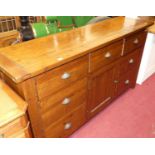 A contemporary stained pine sideboard, fitted with seven drawers and central cupboard door, w.172cm