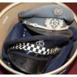 Two hat boxes of various military headwear, to include visor caps, female officers police examples